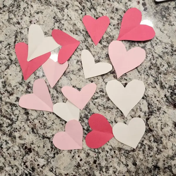 using cut out hearts in red, white, and pink construction paper to make a wreath for a simple valentine's day activity