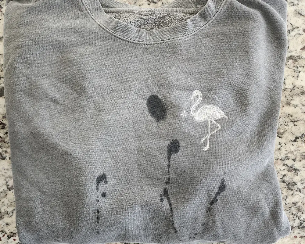A gray sweater with oil stains before using non-toxic stain remover