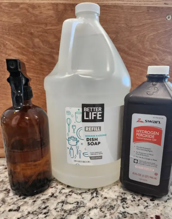 Dish soap and hydrogen peroxide with an amber bottle ready to mix together for non-toxic stain remover
