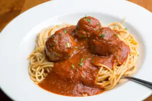 one of the best large family dinner ideas is spaghetti and meatballs. Easy to whip and, and affordable.